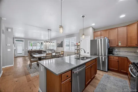 a kitchen with stainless steel appliances granite countertop a sink a stove and a refrigerator
