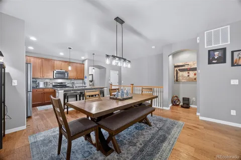 a dining room with stainless steel appliances a dining table and chairs