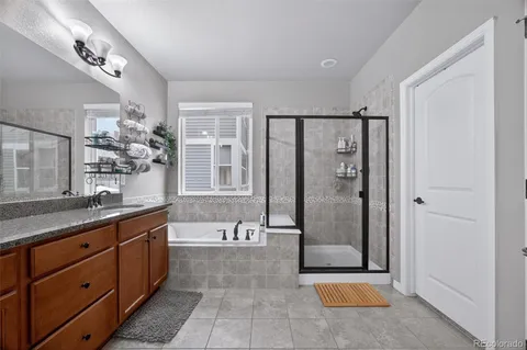 a spacious bathroom with a granite countertop sink a mirror and a bathtub
