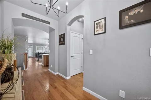 a view of a hallway with wooden floor and a living room