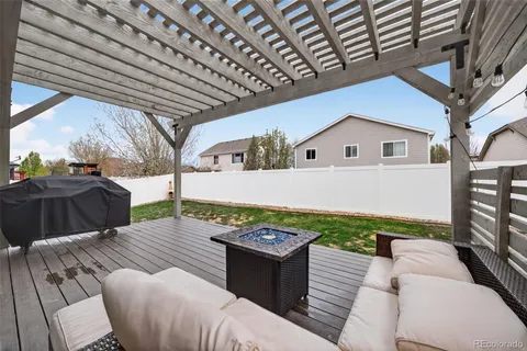 a view of a patio with table and chairs with wooden floor and fence