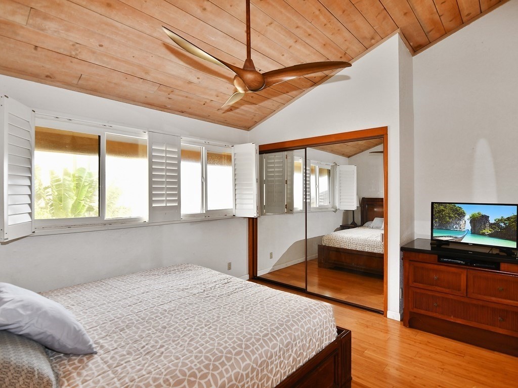 1661 Pee Road, Unit I303 Koloa, HI 96756 - Photo 11 of 15 a bedroom with a bed and wooden floor