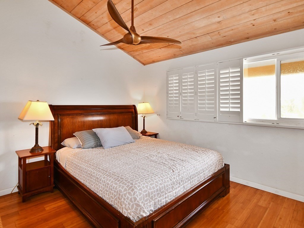 1661 Pee Road, Unit I303 Koloa, HI 96756 - Photo 10 of 15 a bedroom with a bed and lamp with the wooden floor