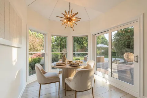 a dining room with furniture a chandelier and glass door