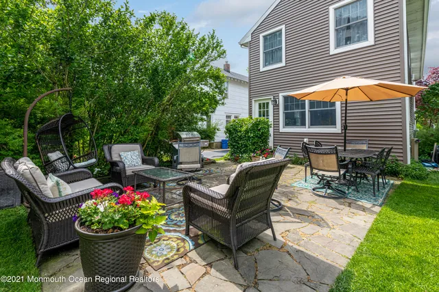 a backyard of a house with a garden and outdoor seating