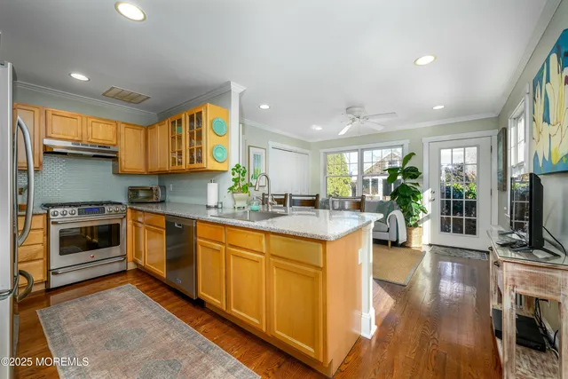 a kitchen with stainless steel appliances granite countertop a stove a sink and a microwave