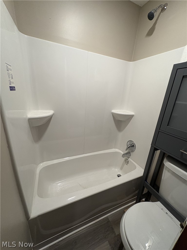727 Wooster Road North Barberton, OH 44203 - Photo 33 of 37 Studio's Bathtub and shower combination featuring an integrated shower surround with two corner shelves, chrome fixtures, and a shower head