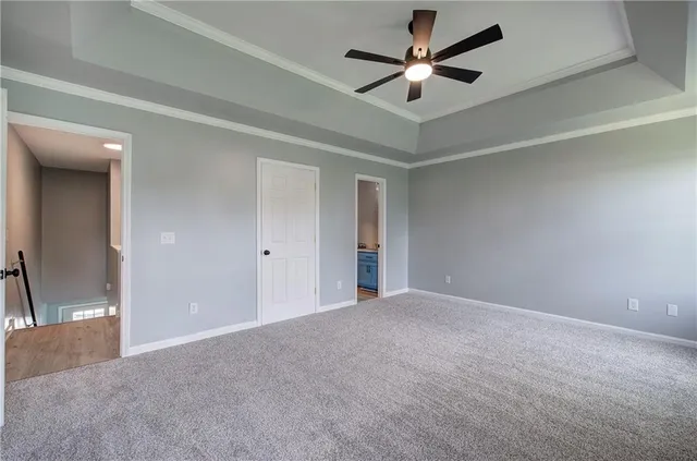 an empty room with closet and a chandelier fan