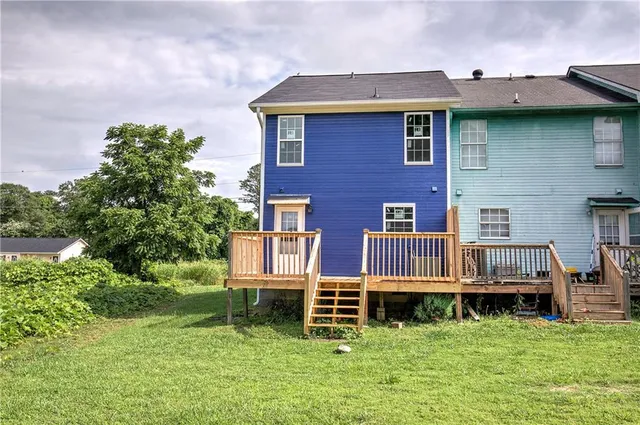 a view of a brick house with a yard and plants