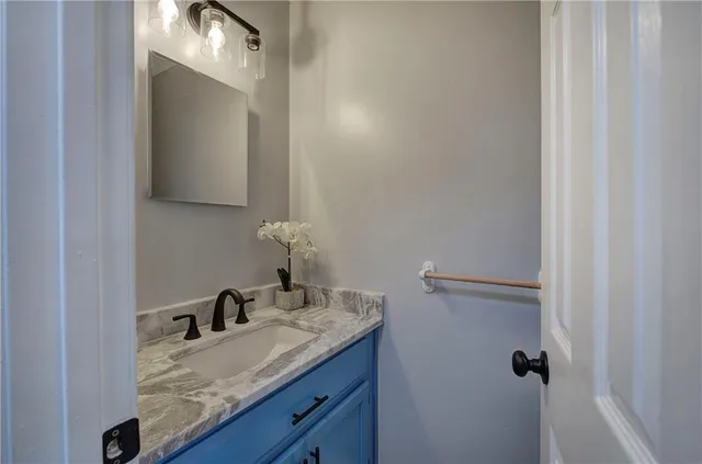 a kitchen with granite countertop wooden floors stainless steel appliances and a window