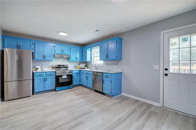 a kitchen with granite countertop wooden cabinets and stainless steel appliances