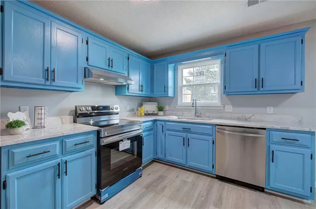 a kitchen with stainless steel appliances granite countertop a stove a refrigerator and a cabinets