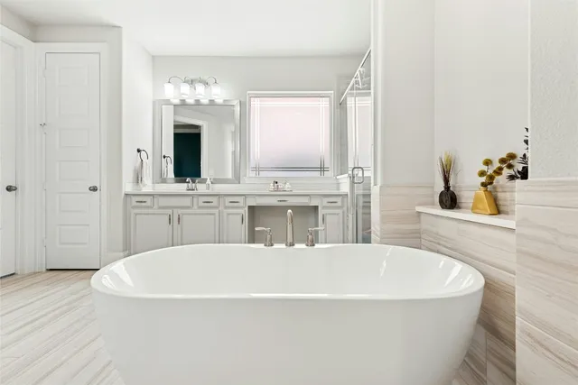 a spacious bathroom with a bathtub sink and mirror