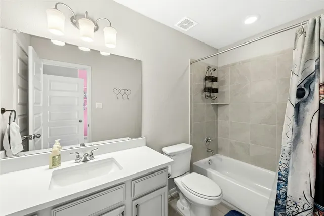 a bathroom with a sink a toilet a mirror a bathtub and shower