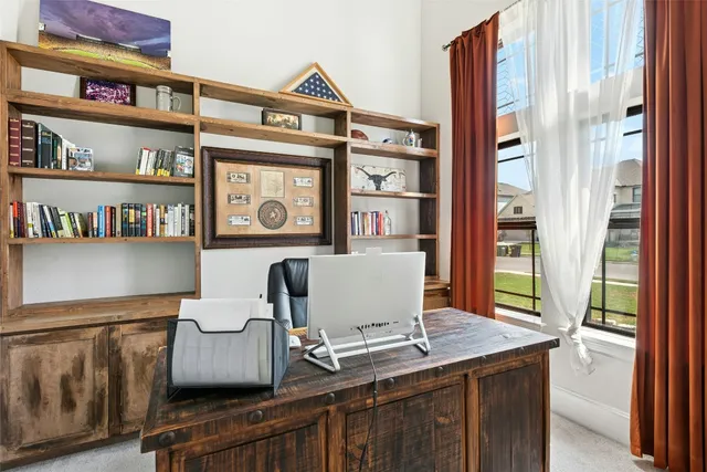 a view of a workspace with furniture and a window