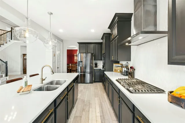 a kitchen with kitchen island granite countertop a sink stainless steel appliances and cabinets