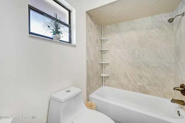 a bathroom with a toilet a sink a mirror and vanity