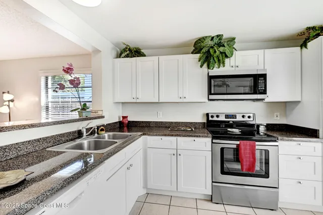 a kitchen with stainless steel appliances a white stove a microwave and a refrigerator