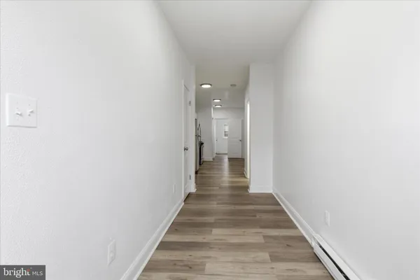 a view of a hallway with wooden floor