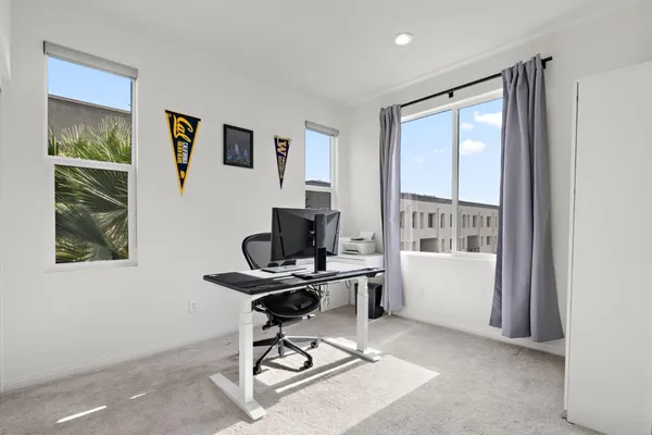 a view of a workspace with furniture and a window