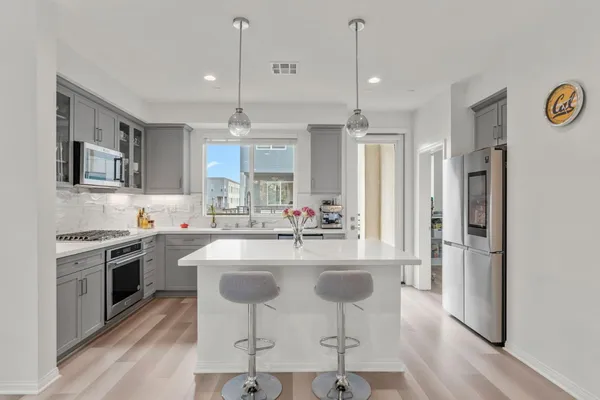 a kitchen with kitchen island granite countertop a stove a sink and a refrigerator