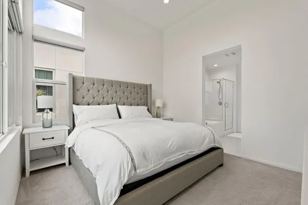 a bedroom with a bed and a large mirror