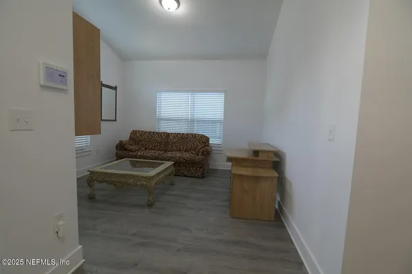 a living room with furniture and a air conditioner vent