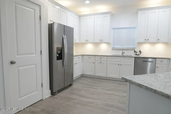 a kitchen with stainless steel appliances granite countertop a refrigerator and a sink