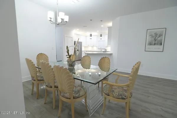 a dining room with furniture a chandelier and wooden floor