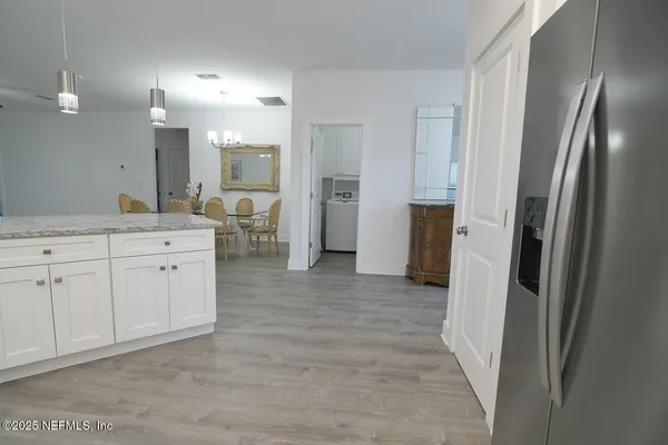 a view of a kitchen with cabinets and wooden floor