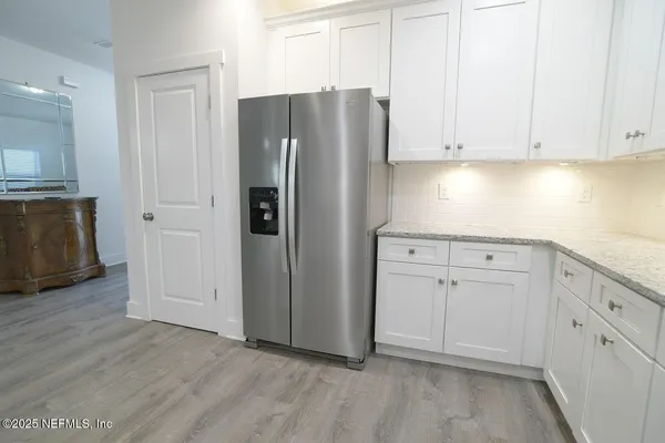a kitchen with stainless steel appliances white cabinets and a refrigerator