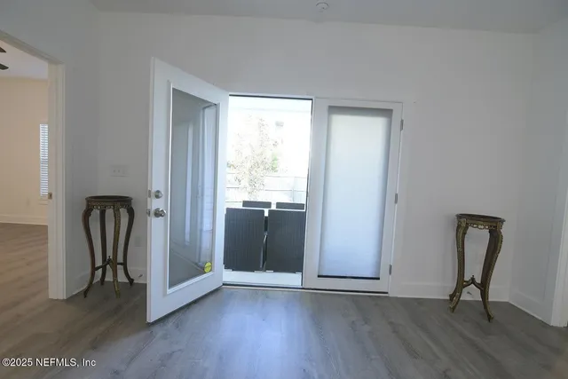 an empty room with wooden floor and mirror