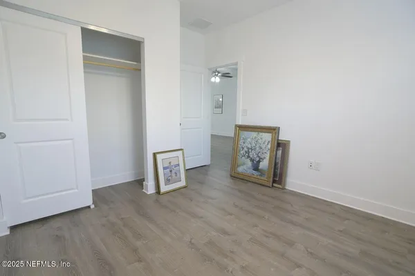 an empty room with wooden floor and mirror