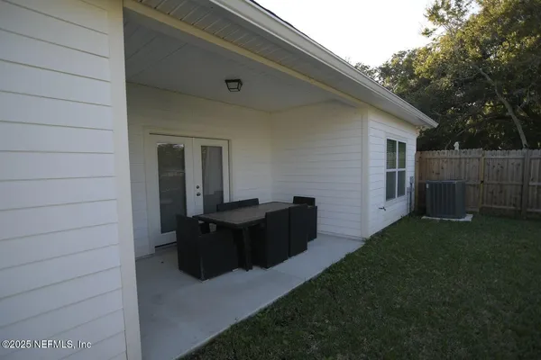 a view of backyard with barbeque grill and wooden fence