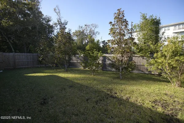 a backyard of a house with wooden fence and a bench