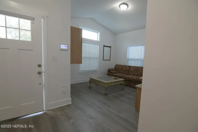 a living room with furniture and a air conditioner vent