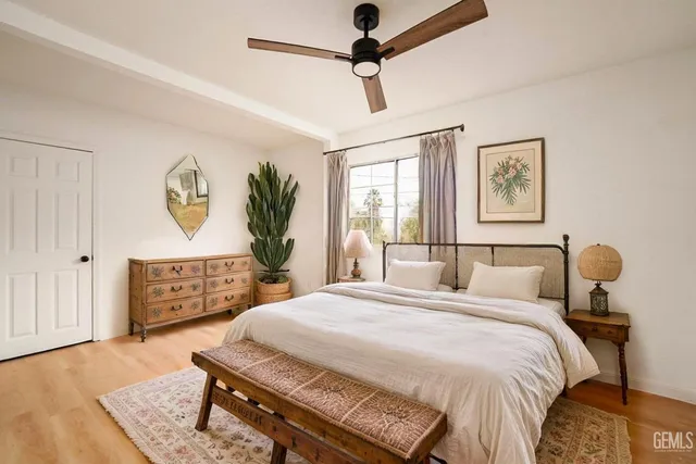 a bedroom with a bed a dresser with wooden floor