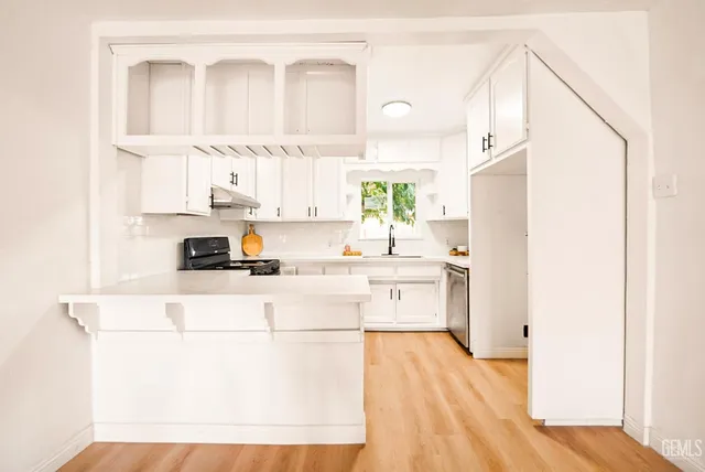 a kitchen with a sink a stove cabinets and a refrigerator