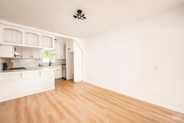 a kitchen with granite countertop white cabinets and white appliances