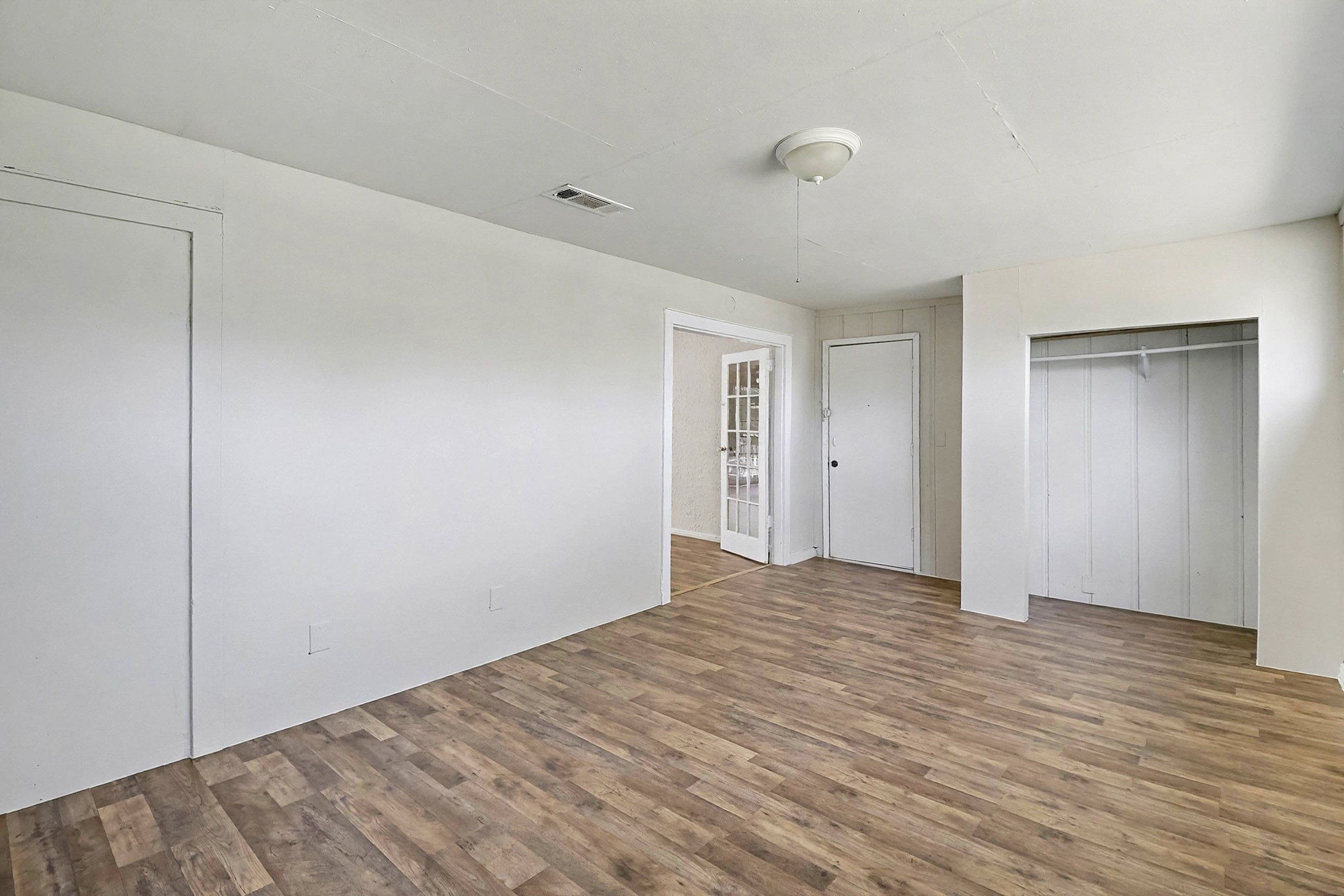 5711 Ridgeway Drive Houston, TX 77033 - Photo 11 of 29 a view of an empty room with wooden floor and a closet