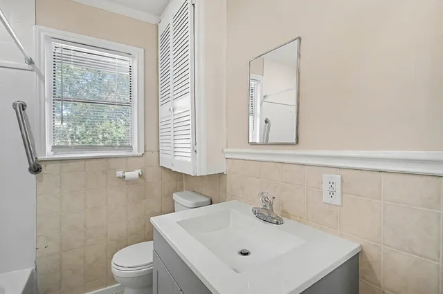 a bathroom with a sink a toilet and a window