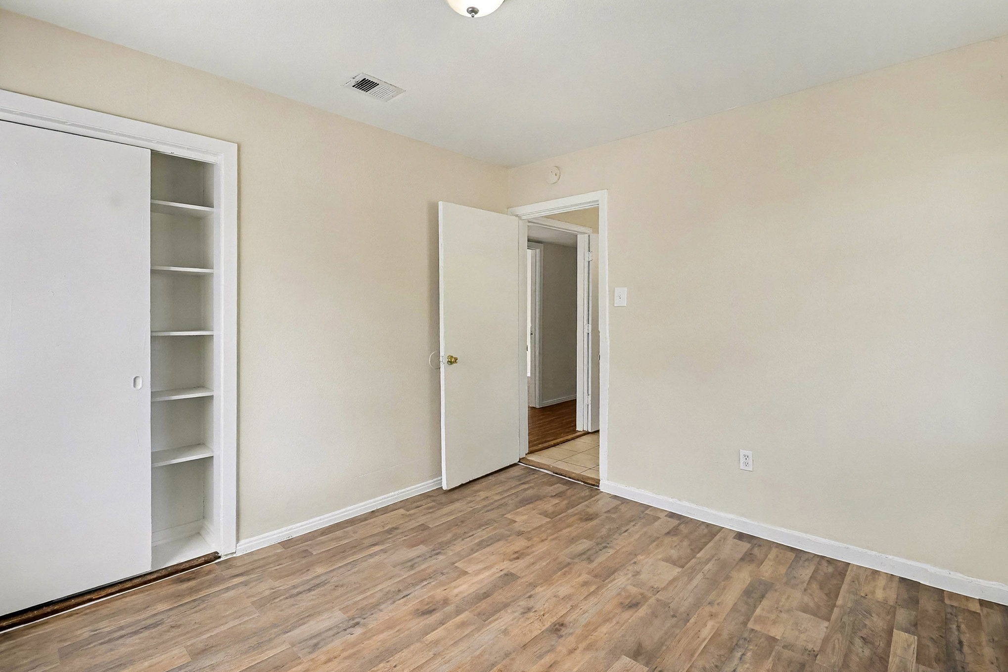 5711 Ridgeway Drive Houston, TX 77033 - Photo 17 of 29 a view of an empty room with wooden floor and closet