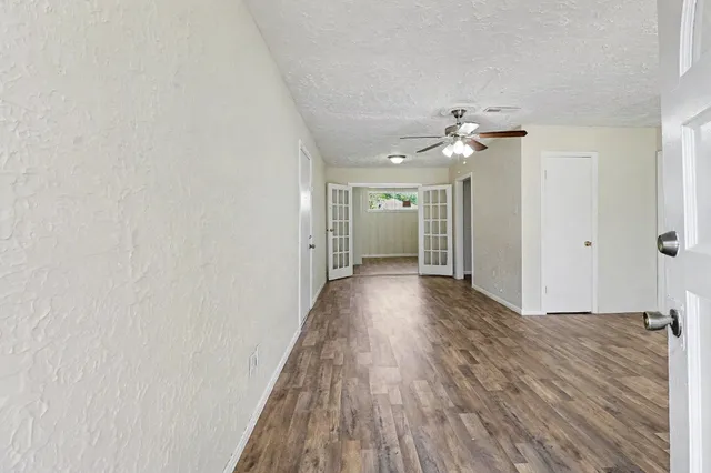 a view of a room with wooden floor and a ceiling fan