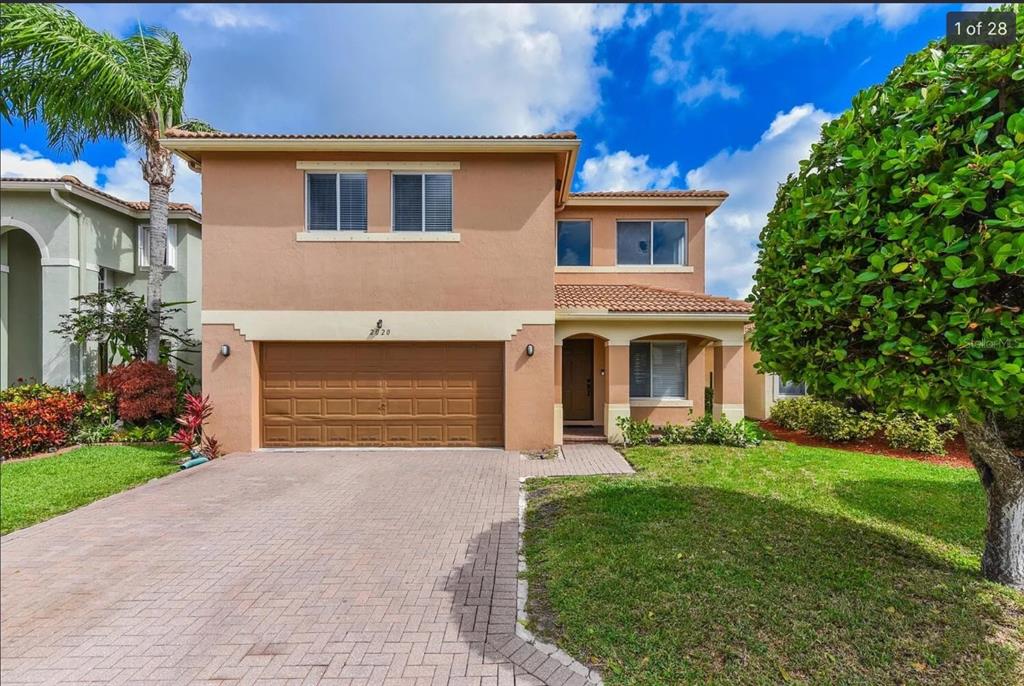 2020 Little Torch Street Riviera Beach, FL 33407 - Photo 1 of 1 a front view of a house with garden and garage