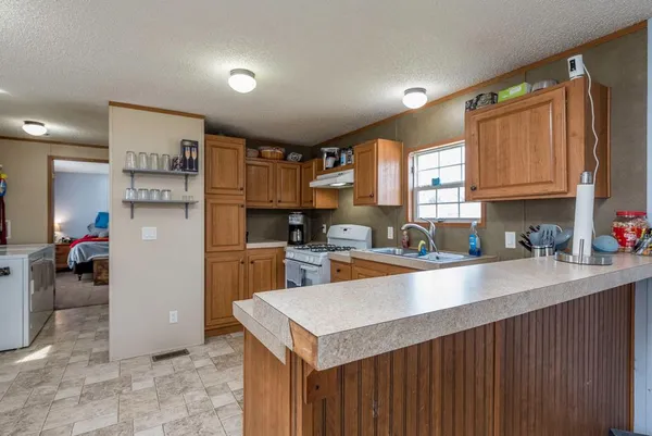a kitchen with a refrigerator a sink dishwasher and a stove with wooden cabinets