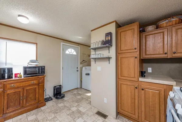 a view of a kitchen with fridge and wooden floor