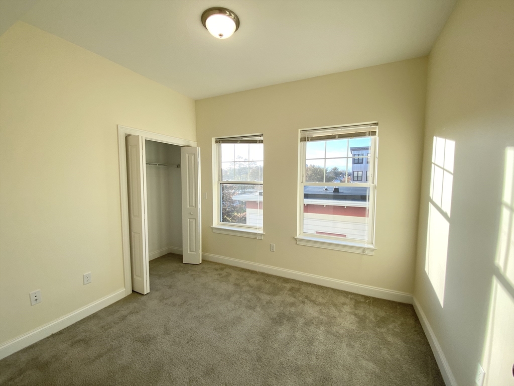 81 Amory Street, Unit 204 Boston, MA 02119 - Photo 7 of 12 an empty room with windows