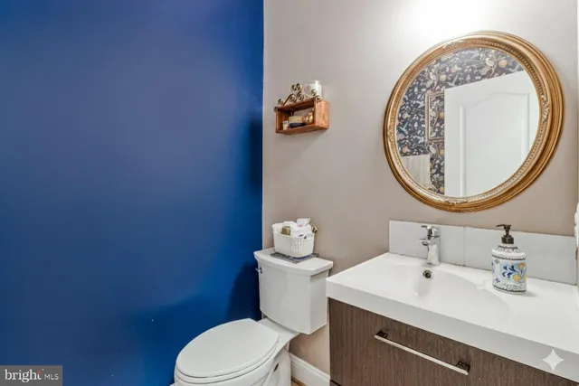 a bathroom with a sink mirror and toilet