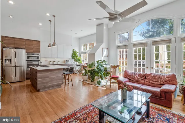 a kitchen with a table chairs stainless steel appliances and wooden floor