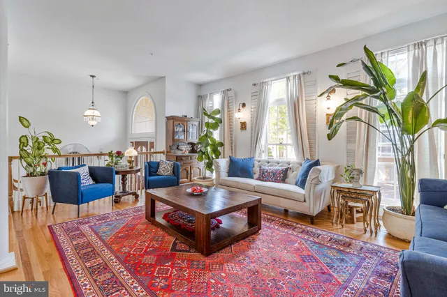 a living room with furniture a large window and a rug